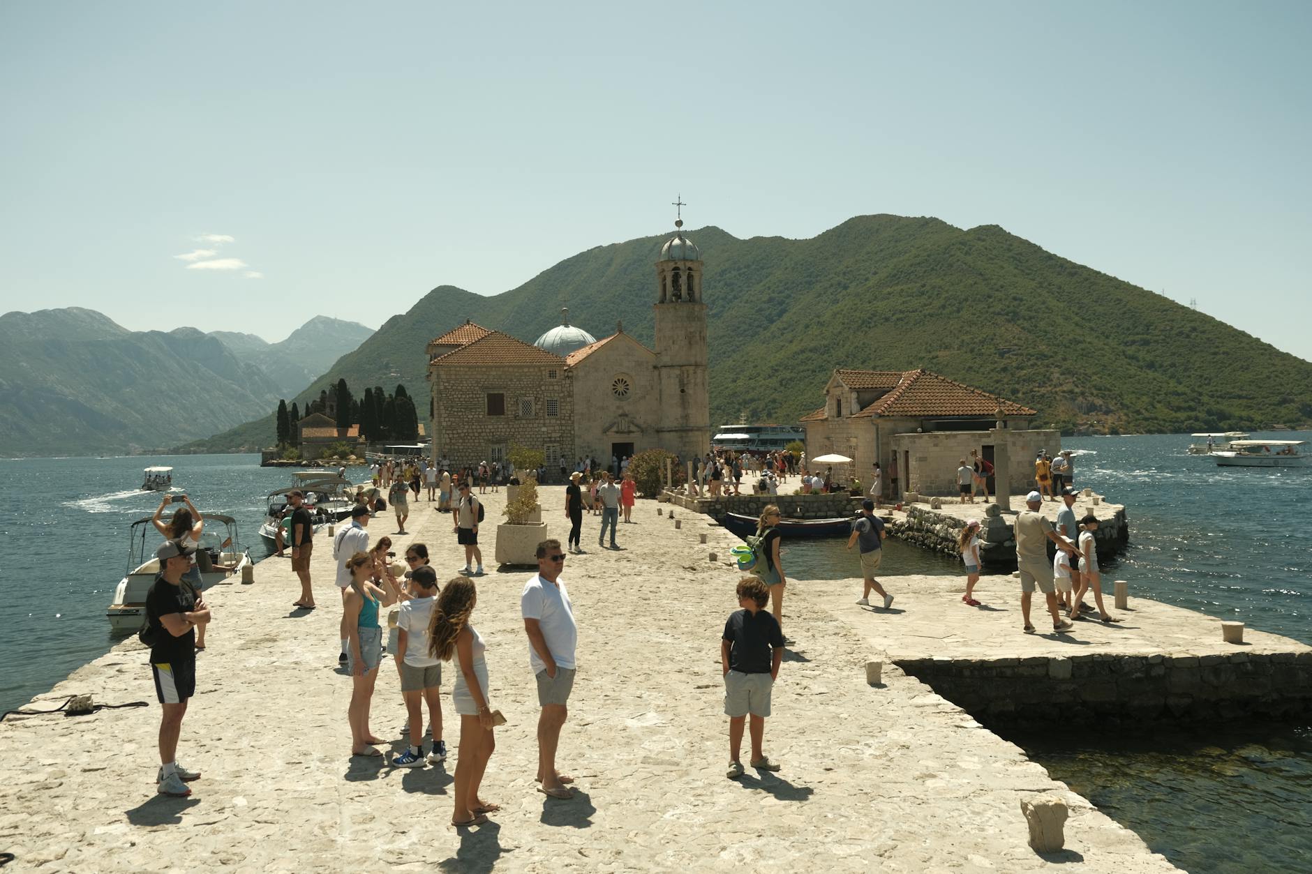 Turyści zwiedzający kamienną wyspę i sanktuarium na morzu w słoneczny dzień