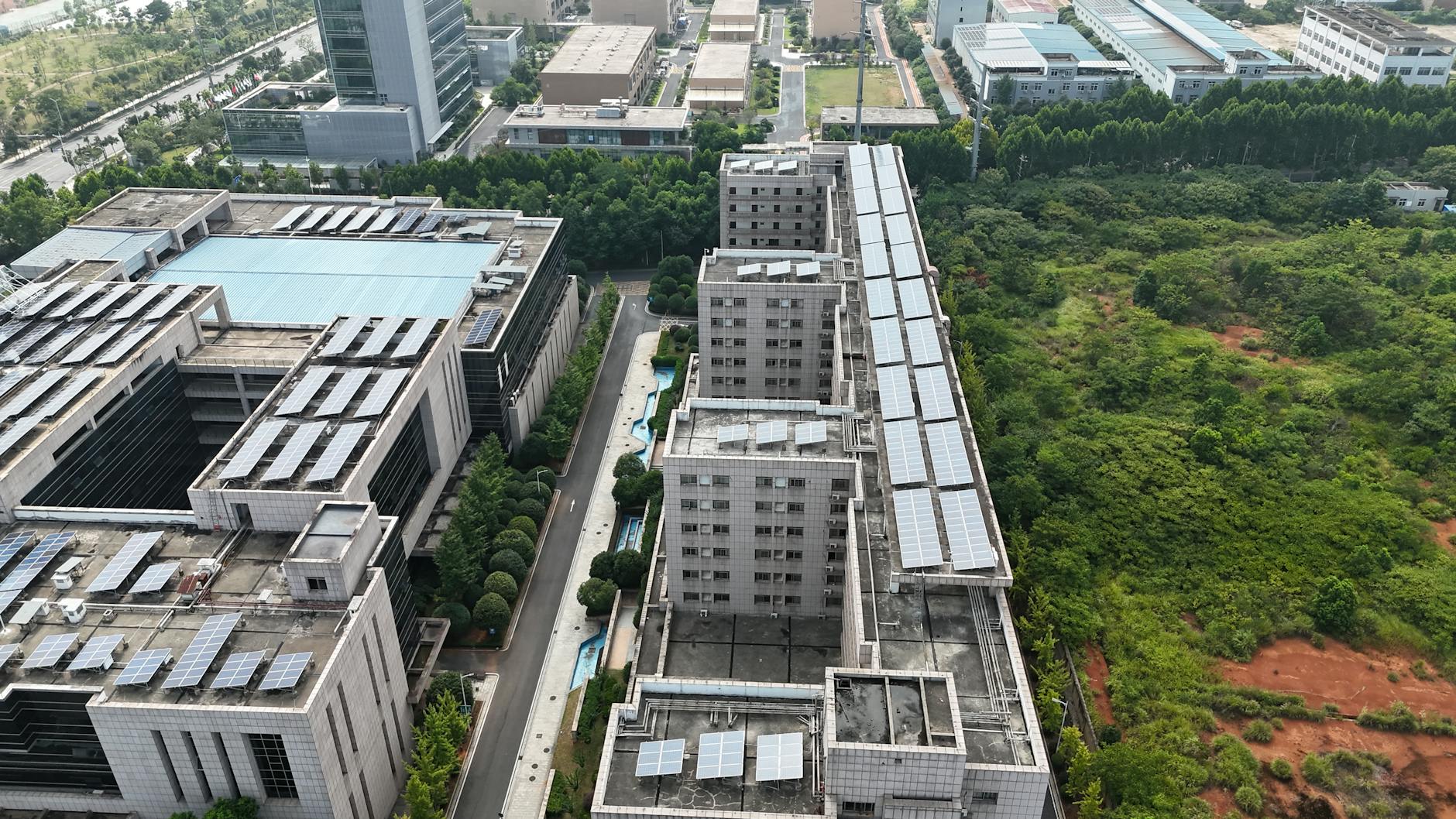 Panorama miasta z dachami pokrytymi panelami słonecznymi i terenami zielonymi