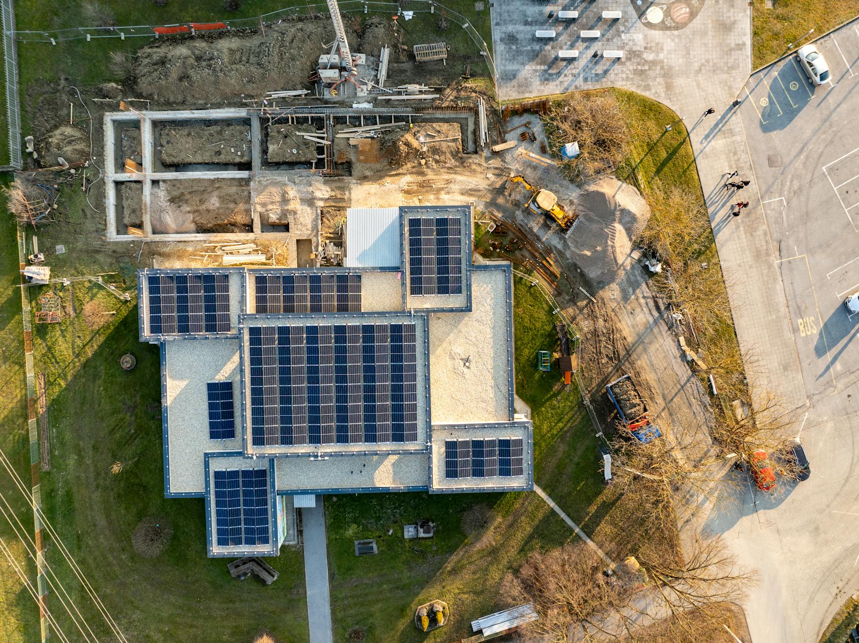 Widok z góry na budynek z panelami fotowoltaicznymi w trakcie budowy
