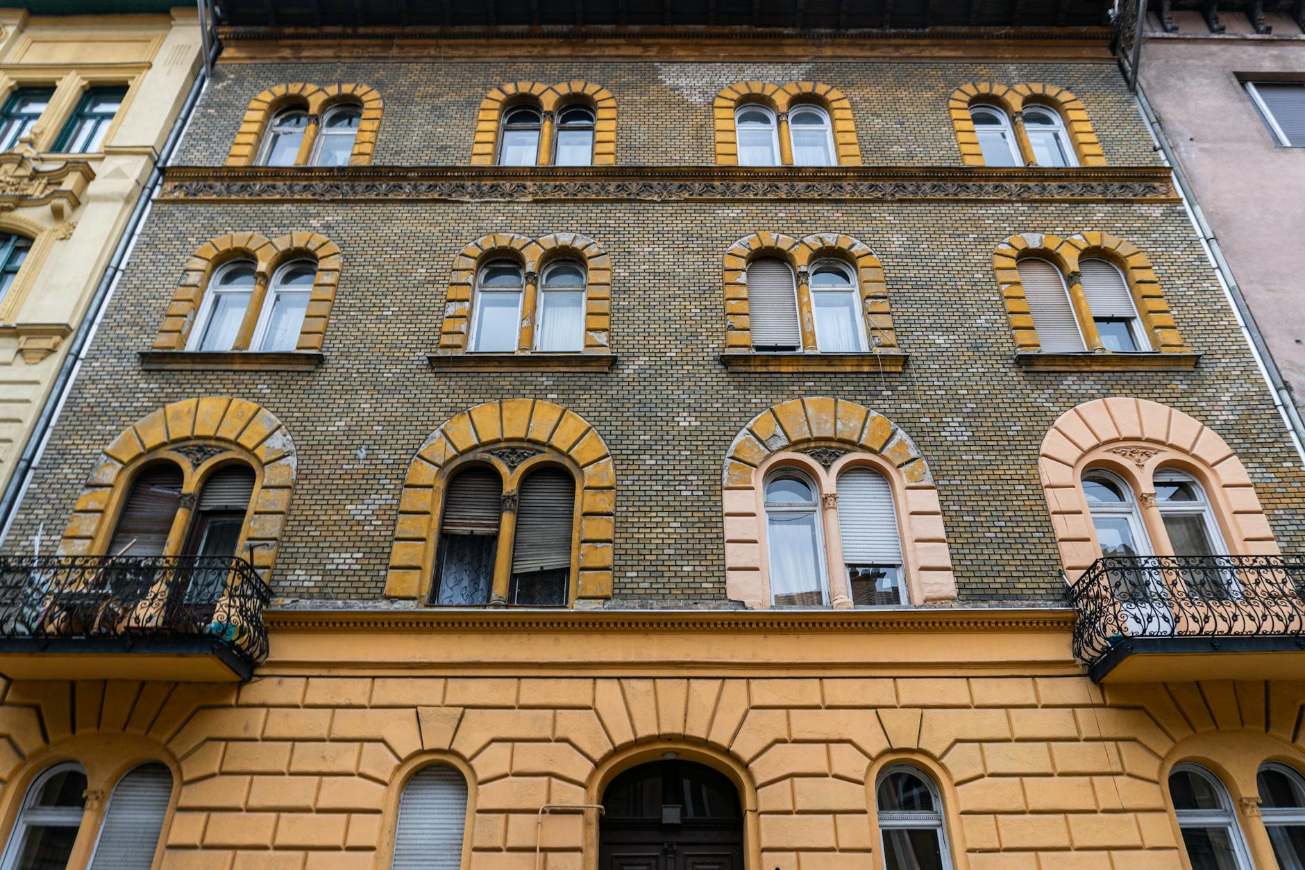 Zbliżenie klasycznej europejskiej elewacji z łukowymi oknami i cegłą