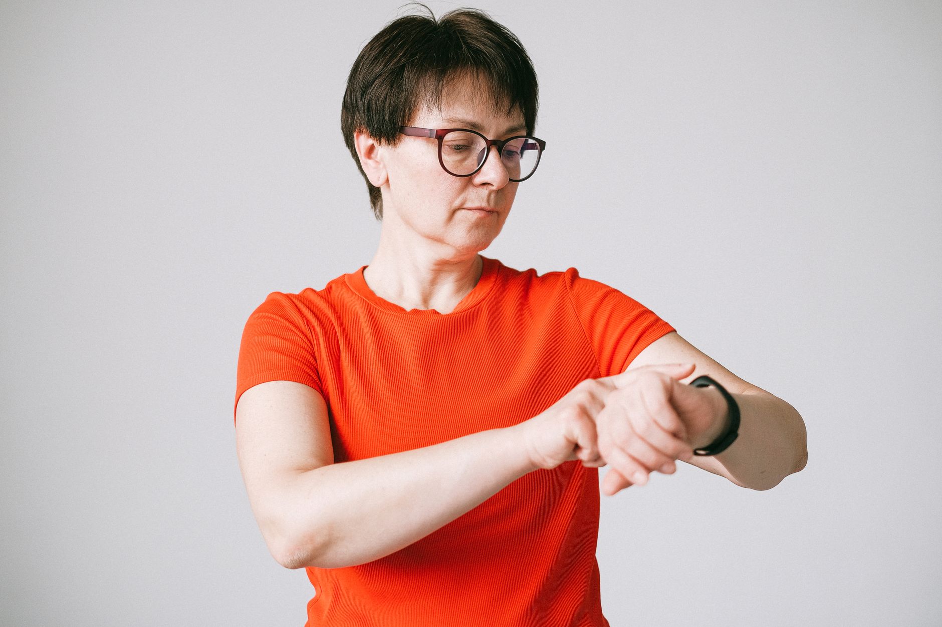 Kobieta w okularach sprawdza smartwatch w jasnym, minimalistycznym wnętrzu