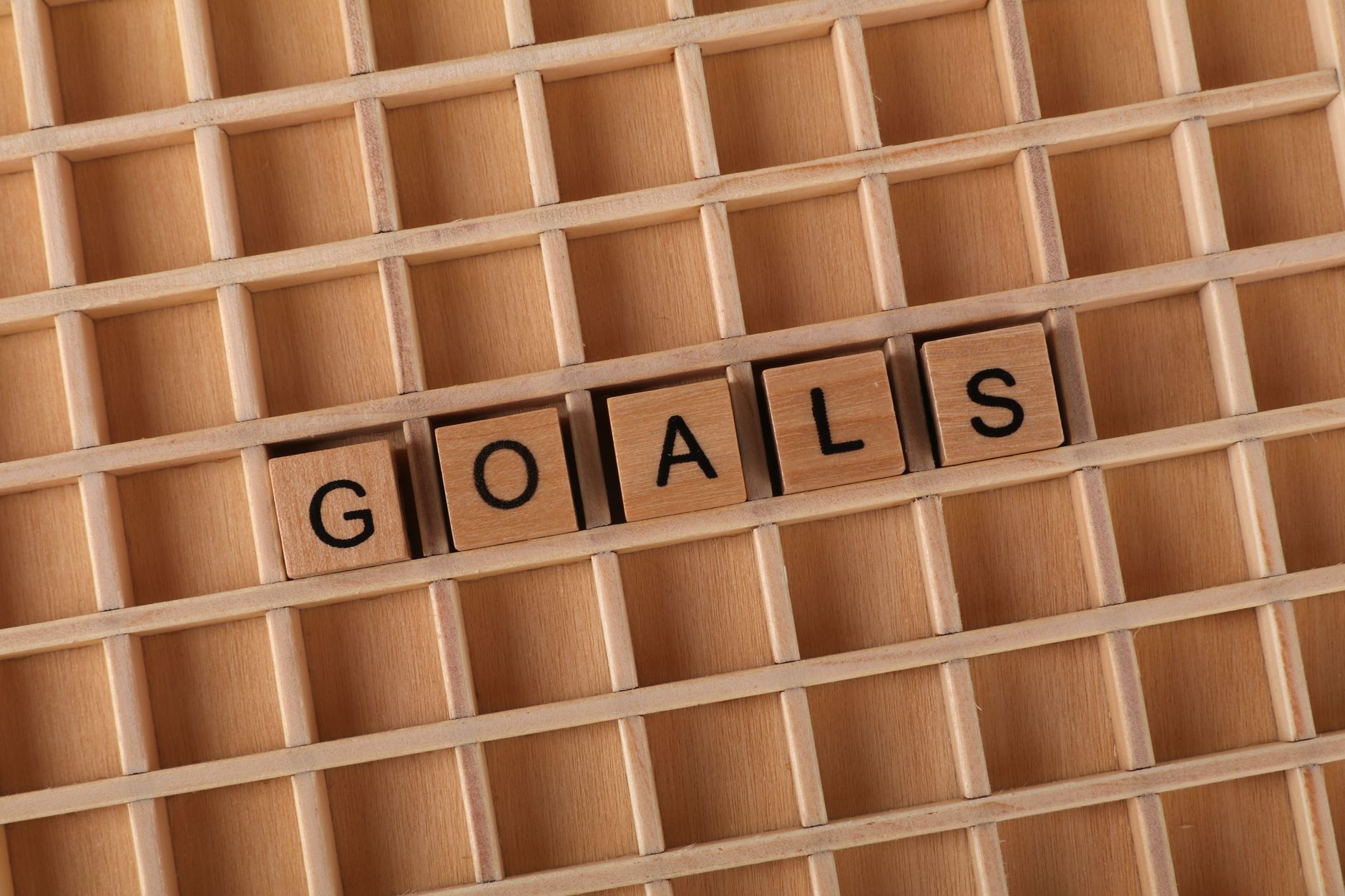 Drewniane klocki z napisem Goals ułożone na planszy jak cele w projekcie