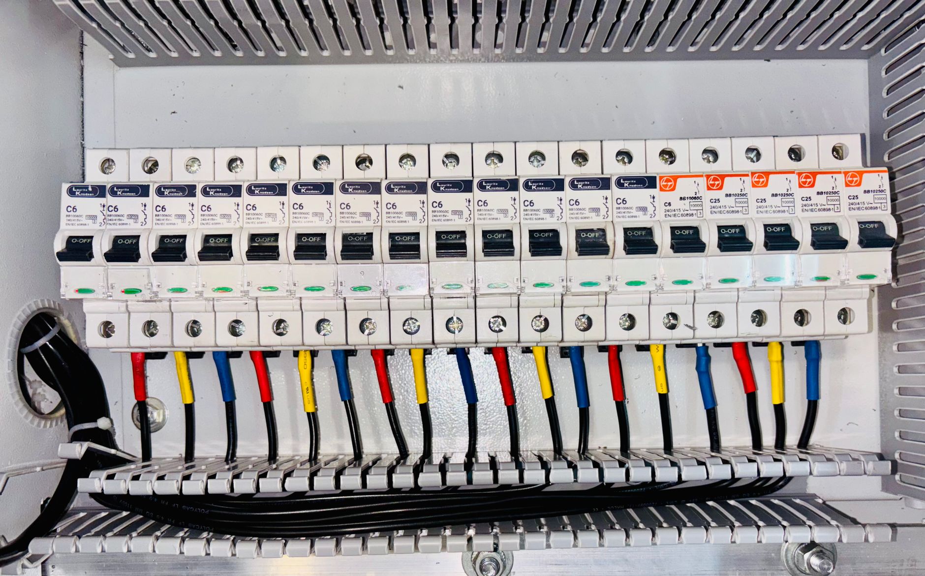 Zbliżenie na uporządkowaną rozdzielnicę z kolorową instalacją elektryczną